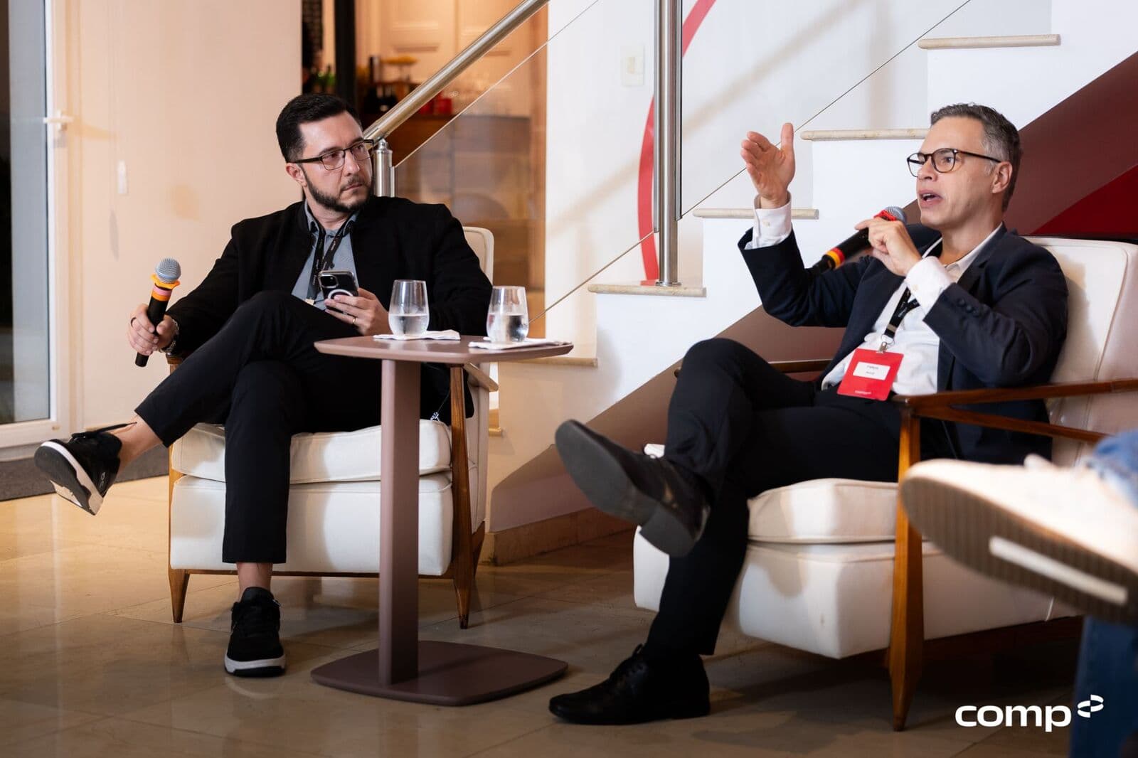 Dois líderes debatendo em poltronas durante o encontro
